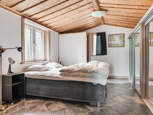 a bedroom with a large bed and windows at Holiday Home Nedre Gärdsjö by Interhome in Rättvik