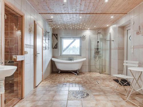 a bathroom with a tub and a shower and a sink at Holiday Home Nedre Gärdsjö by Interhome in Rättvik