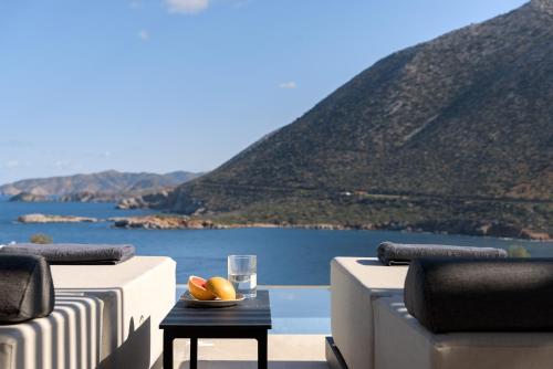 a table with a bowl of fruit and a glass of water at Cueva Villas, with Pool, SeaViews & close to Sea, By ThinkVilla in Balíon