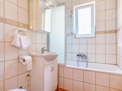 a bathroom with a sink and a tub and a toilet at Apartment Delfin-10 by Interhome in Cesarica