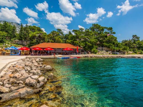 a beach with a restaurant and the water at Apartment Delfin-2 by Interhome in Cesarica
