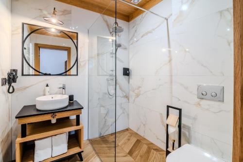 a bathroom with a sink and a shower at Hotel Maria & Spa in Szczawnica