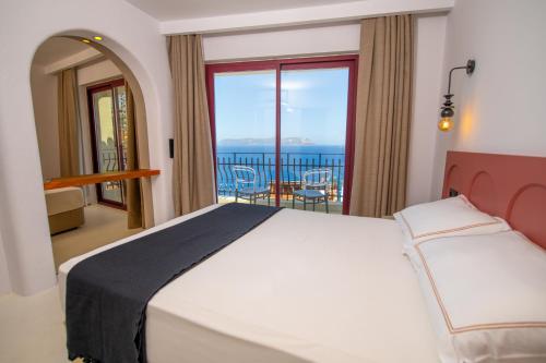 a bedroom with a bed and a view of the ocean at Hotel Begonvil in Kas