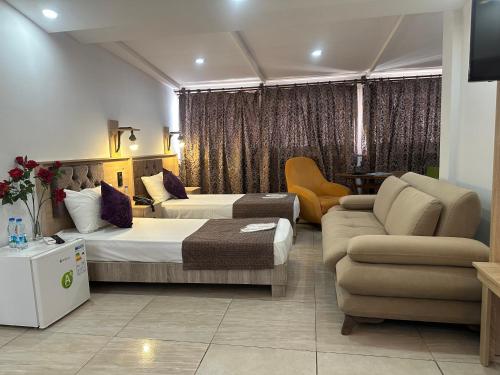 ein Hotelzimmer mit zwei Betten und einer Couch in der Unterkunft Beyond OTEL in Antalya