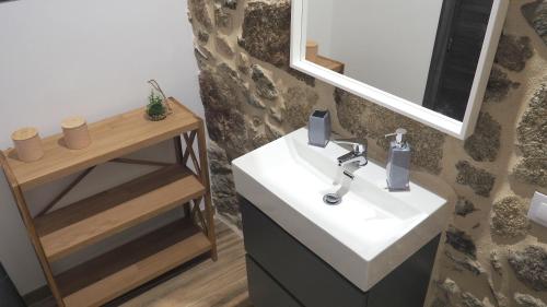 a bathroom with a white sink and a mirror at Apartamentos Muralla Sacra in Sober