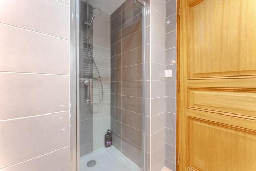 une douche avec une porte vitrée dans une salle de bain dans l'établissement Charmant T3 au cœur de Nantes, à Nantes