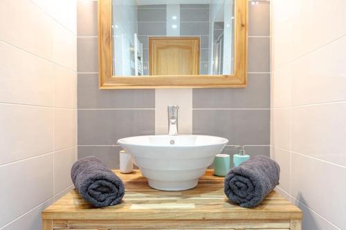 une salle de bain avec un lavabo, un miroir et des serviettes dans l'établissement Charmant T3 au cœur de Nantes, à Nantes