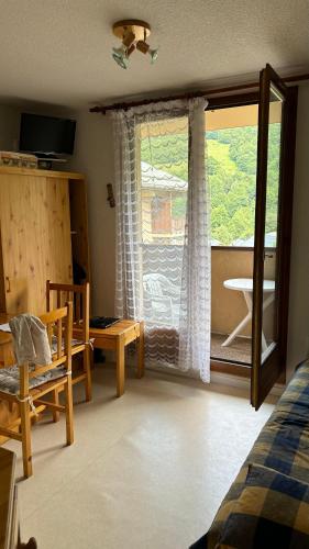 - une chambre avec une fenêtre, une table et une chaise dans l'établissement Les Thymels, à Valloire