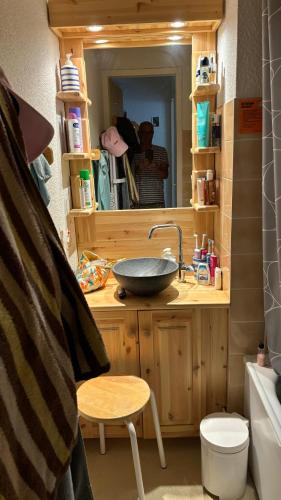 une personne prenant une photo d'une salle de bains avec lavabo dans l'établissement Les Thymels, à Valloire
