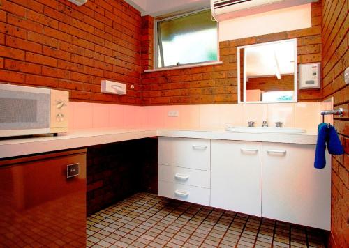 a kitchen with a sink and a microwave at Wattle Motel in Seymour