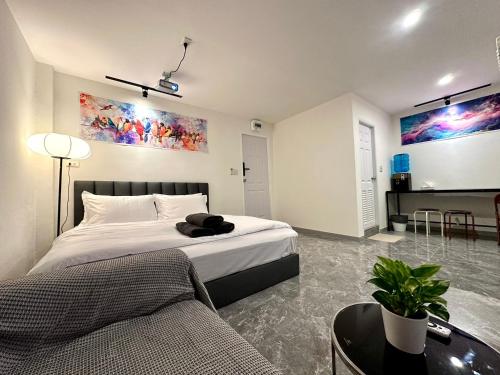 a bedroom with a bed and a couch at The White Den Chatuchak in Bang O