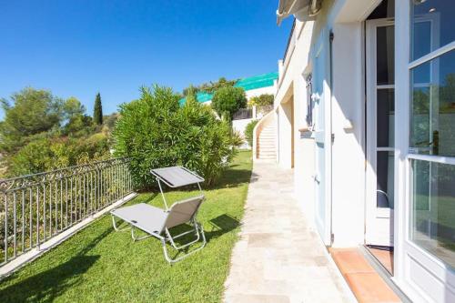 a balcony with a table and a chair on the grass at Villa Colomars sea view-swimming pool, terrace&BBQ in Colomars