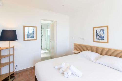 a bedroom with a white bed with towels on it at Villa Colomars sea view-swimming pool, terrace&BBQ in Colomars