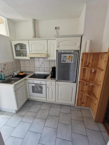 a kitchen with white cabinets and a sink at SaxonyBNB in Waldheim
