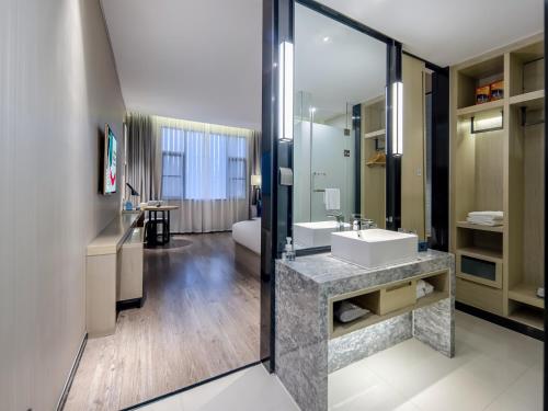 a bathroom with a sink and a large mirror at Echarm Hotel Nanning the MixC Exhibition Center Metro Station in Nanning
