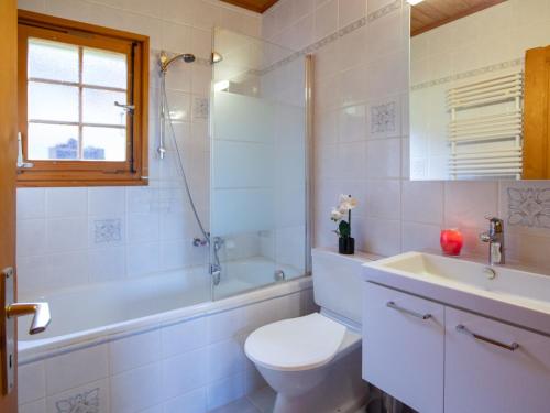 a bathroom with a toilet and a tub and a sink at Chalet Chalet Lorila by Interhome in Villars-sur-Ollon
