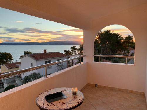 a balcony with a table and a view of the ocean at Apartment Sanda in Stomorska