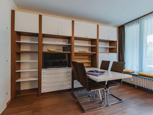 a dining room with a table and chairs and a tv at Apartment Schlossalmblick by Interhome in Bad Hofgastein