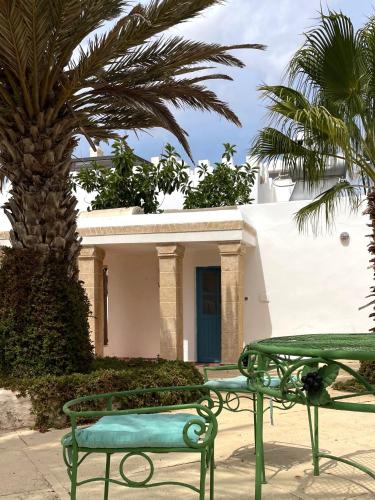 a house with a green table and a palm tree at Hotel Villa Soleil in Sidi Kaouki