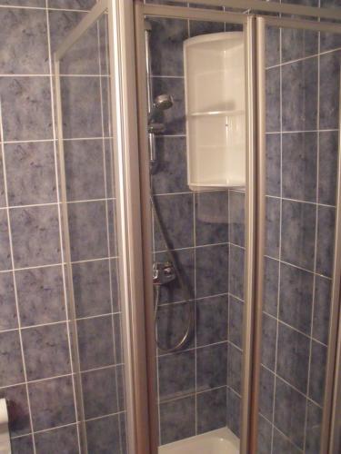 La salle de bains est pourvue d'une douche et de carrelage gris. dans l'établissement Le Ciel Bleu, à Châtel