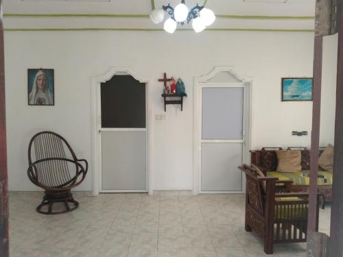a room with white walls and two doors and a chair at Diana's place in Negombo