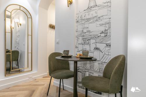 une salle à manger avec une table, des chaises et un dessin mural dans l'établissement MBA - Saint-Sébastien- Splendide Appartement Paris Centre, à Paris