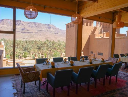 a table in a room with a view of the mountains at Kasbah Hnini in Igdourane