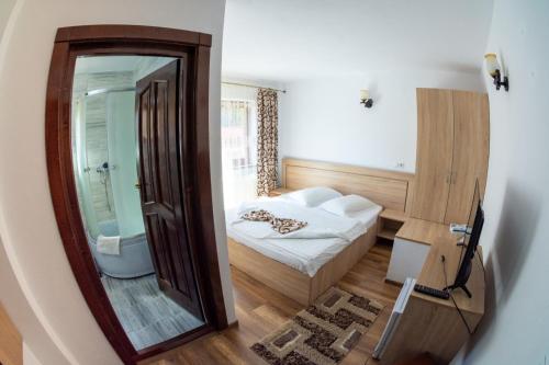 a small room with a bed and a mirror at Cabana Dan Arieseni in Arieşeni