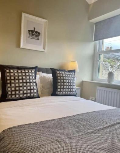 a bedroom with a bed with pillows and a window at Queens Cottage in Skipton