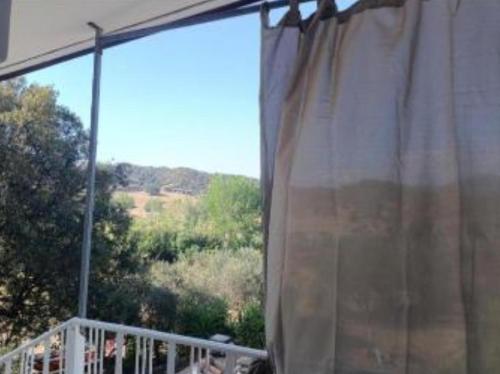 a curtain in a window with a view of trees at VILLALoddo4 Marina di Tertenia cap 08047 dietro Ristorante La Grotta in Tertenìa