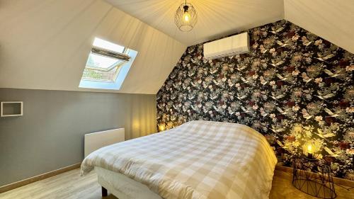 una camera con un letto con una parete floreale di Cottage Blue Birdie a Cucq