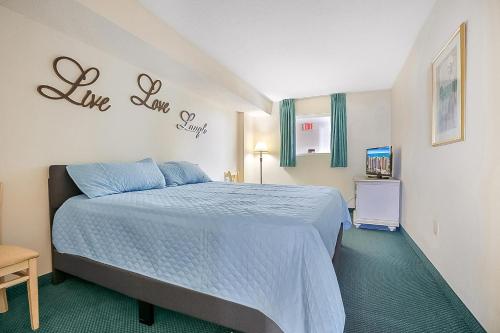 a bedroom with a bed and a sign that says live love worry at Bay Watch Resort | Oceanfront | King Suite | Budget Friendly in Myrtle Beach