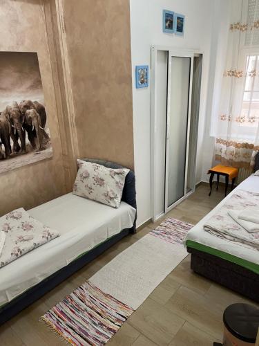 a room with two beds and a couch at Sobe sa sopstvenim KUPATILOM Private rooms bathroom In CENTER in Novi Sad