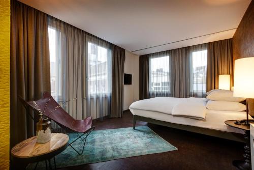 une chambre d'hôtel avec un lit, une table et des fenêtres dans l'établissement Hotel V Nesplein, à Amsterdam