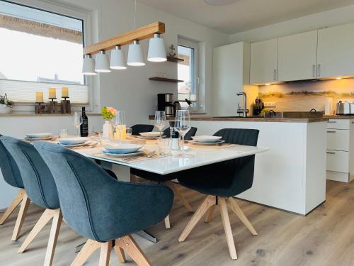 a kitchen with a dining room table and chairs at Reetdach-Ferienhaus "ANNI" mit direktem Meerblick, Sauna und Kamin in Pepelow