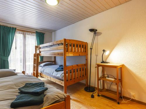 a bedroom with two bunk beds and a lamp at Apartment La Tour d'Antheme by Interhome in Champéry
