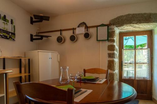 une cuisine avec une table en bois et une salle à manger dans l'établissement Le four, ferme de la beyssiere, à Saint-Jean-Chazorne