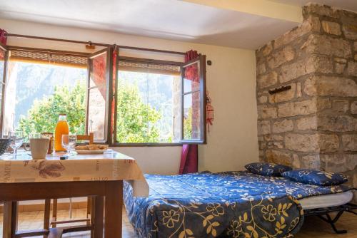 une chambre avec un lit, une table et des fenêtres dans l'établissement Gîte Gîte 