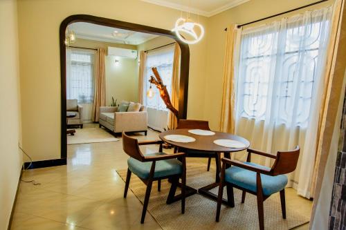 a dining room with a table and chairs and a mirror at Kwetu Maili6Homes 02 in Moshi