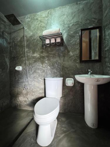 a bathroom with a toilet and a sink at Dam Dam Place in San Vicente