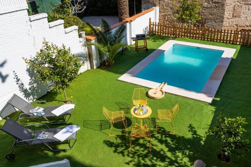 Elle offre une vue sur une arrière-cour dotée d'une piscine et de chaises. dans l'établissement Genteel Home San Nicolas, à Grenade