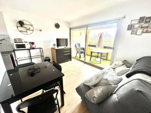 - un salon avec un canapé et une table dans l'établissement Le Sopraland 203, Joli T2 avec piscine et parking, au Cap d'Agde