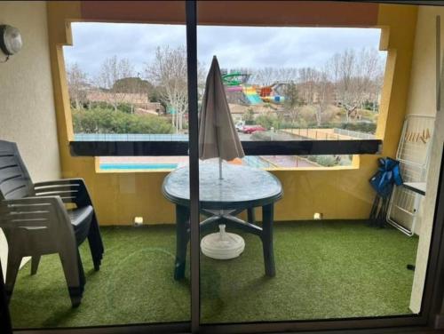 une chambre avec une table et une planche de surf dans l'établissement Le Sopraland 203, Joli T2 avec piscine et parking, au Cap d'Agde