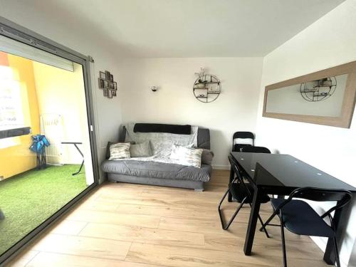 un salon avec un canapé et une table dans l'établissement Le Sopraland 203, Joli T2 avec piscine et parking, au Cap d'Agde