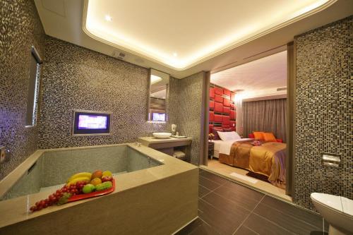a bathroom with a tub with a sink and a bed at Chusha Motel in Gongguan
