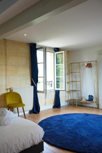 - une chambre avec un lit et un tapis bleu dans l'établissement Château Vieux Clos Saint Émilion, à Saint-Émilion