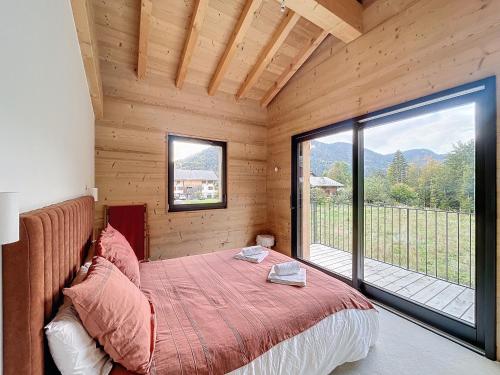 a bedroom with a bed and a large window at Chalet Beli - Montriond - Centre village in Montriond