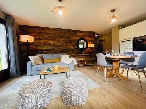 a living room with a couch and a table at Appartement style chalet avec grande terrasse et parking prive in Chamonix-Mont-Blanc