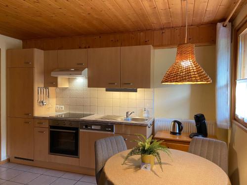 une cuisine avec une table et un éclairage dans l'établissement La Joly - ChaletYap, à La Chapelle-dʼAbondance