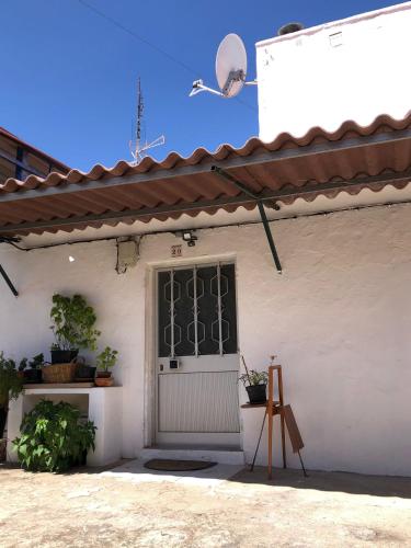 a white house with a door and a window at Casa das Casas Novas - Beco das Avós in Elvas